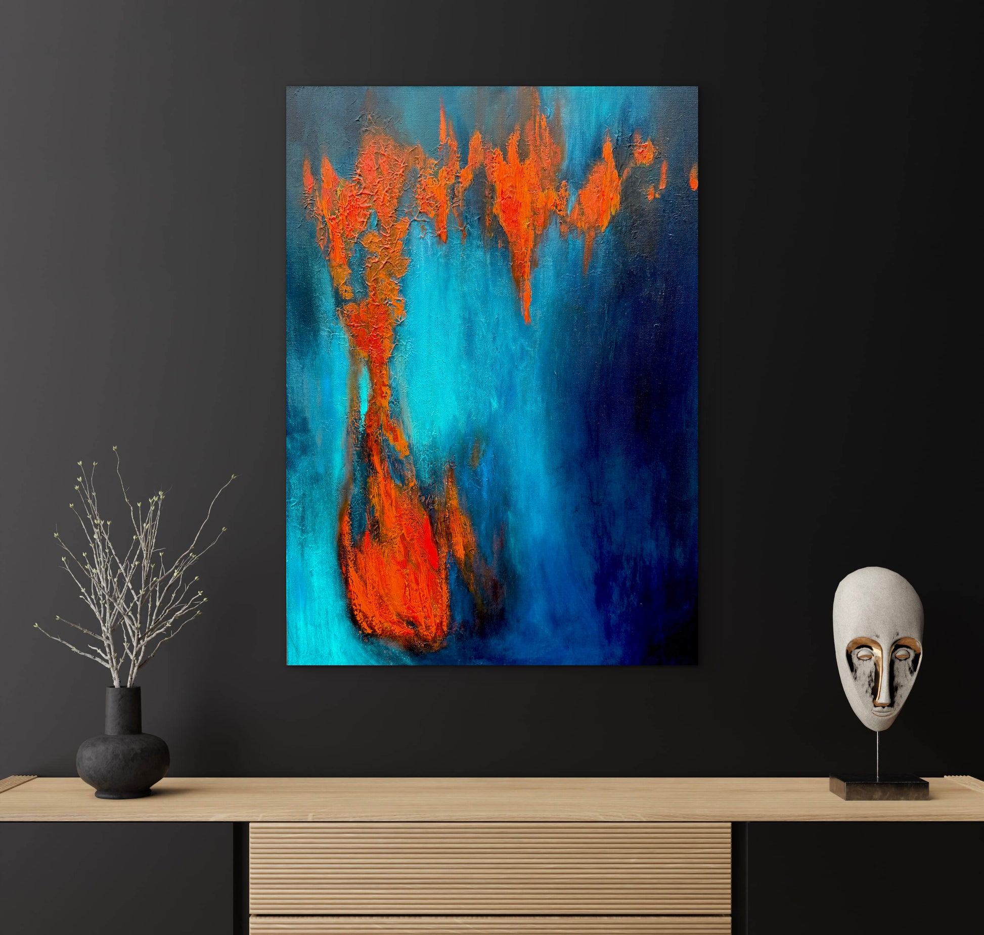 Abstract painting with orange and blue colors on a black wall above a wooden shelf.