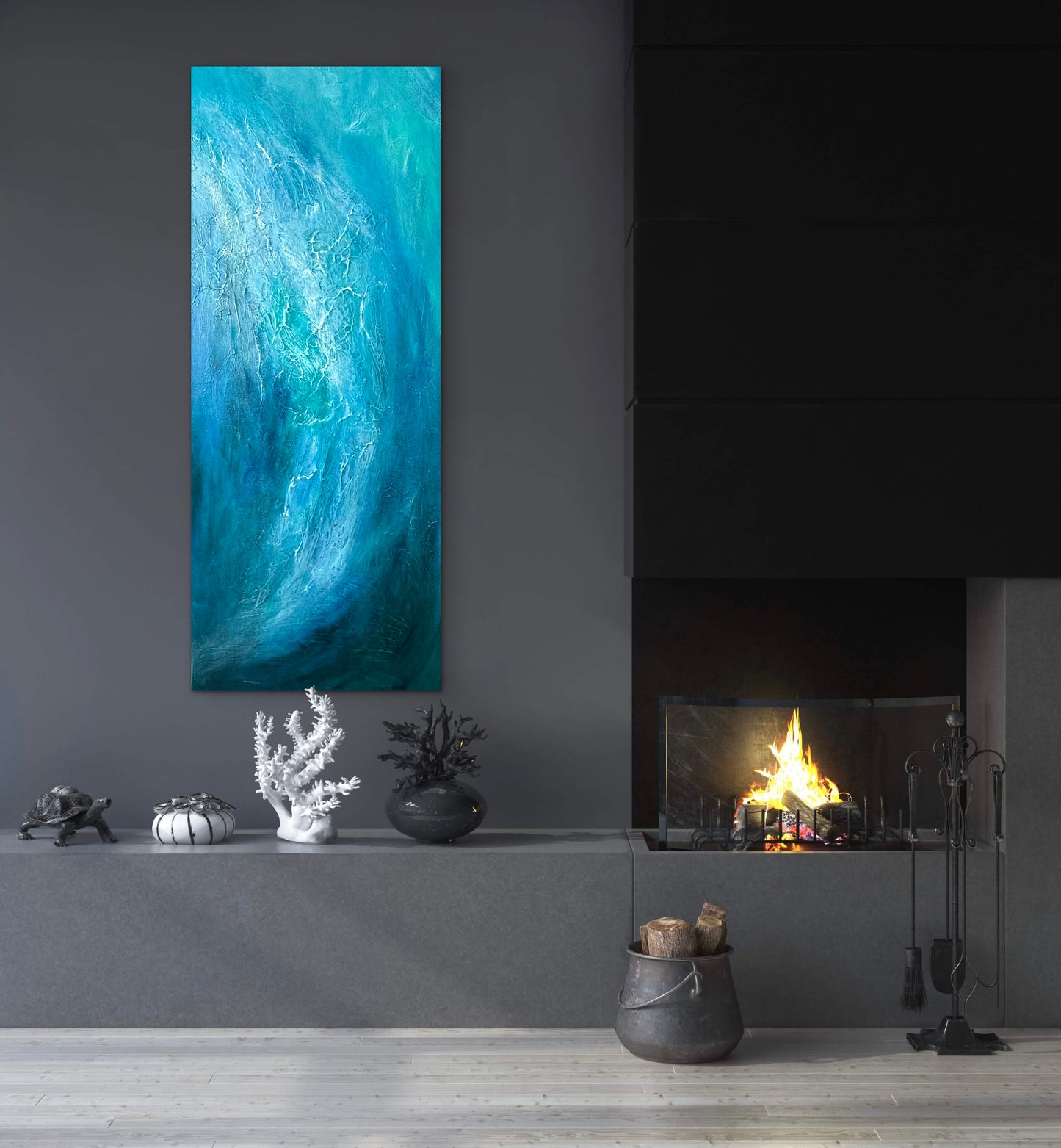 A tall vertical canvas print featuring an abstract blue and turquoise wave design, displayed on a dark gray wall above a modern fireplace mantel with decorative objects.